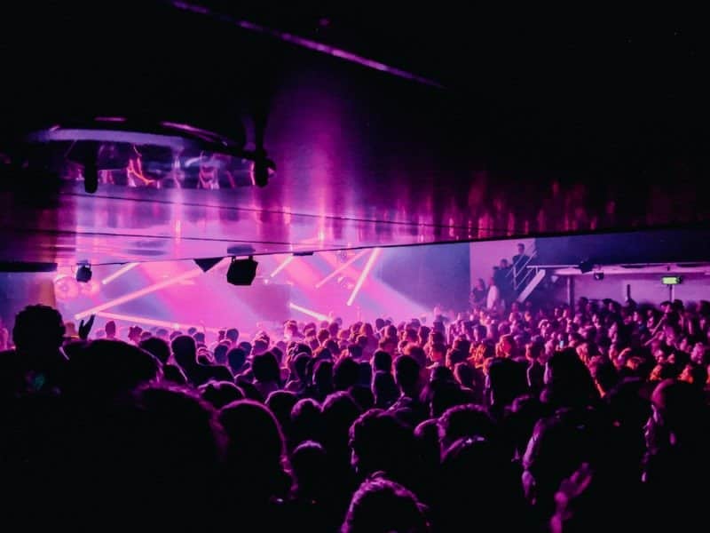 Young crowd listening to electronic music show at night in Amsterdam