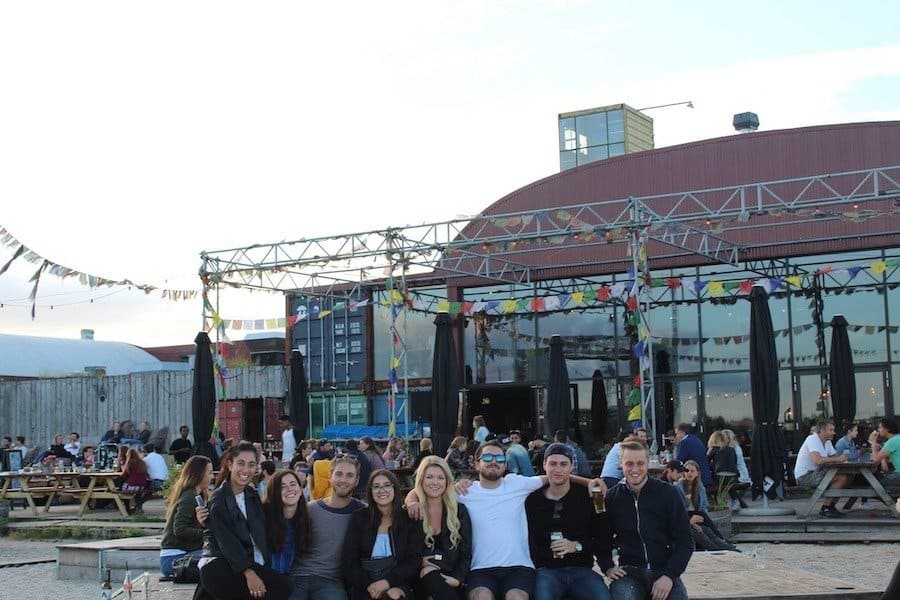 Group of friends sitting in front of the Pllek building