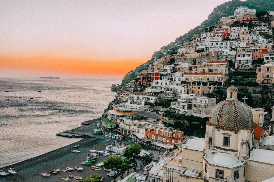 Colour Positano buildings with Santa Maria Church in the foreground. Sun is setting in the background