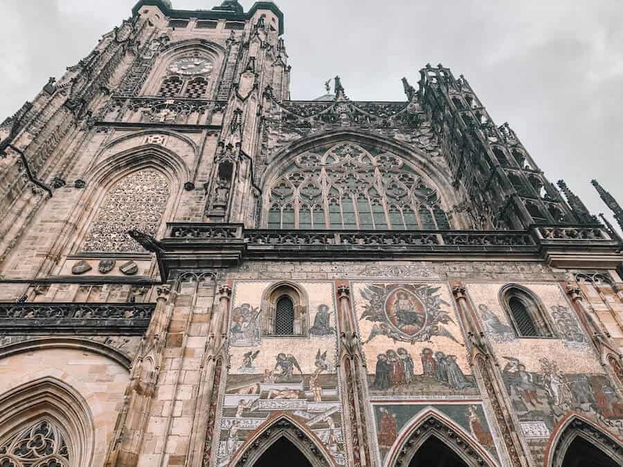 Huge gothic building with black details and religious murals 