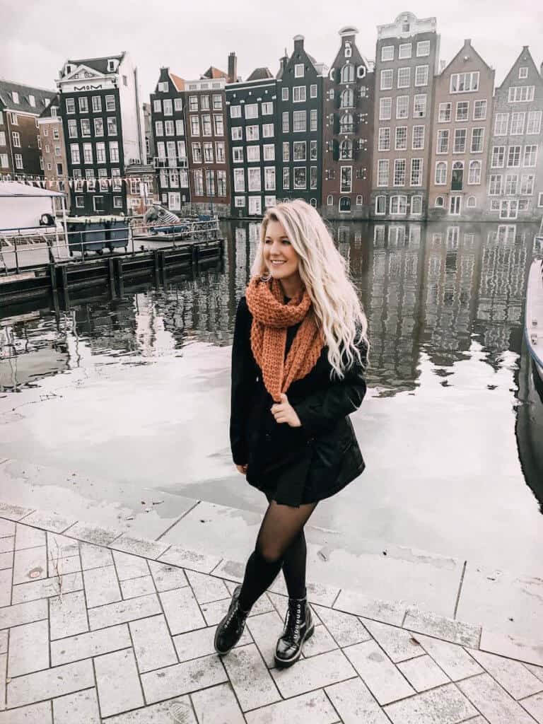 Blonde girl stand in the best photo spot in Amsterdam the gingerbread houses