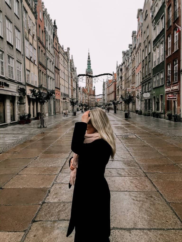 Blonde girl standing in the middle of a colour street in Poland