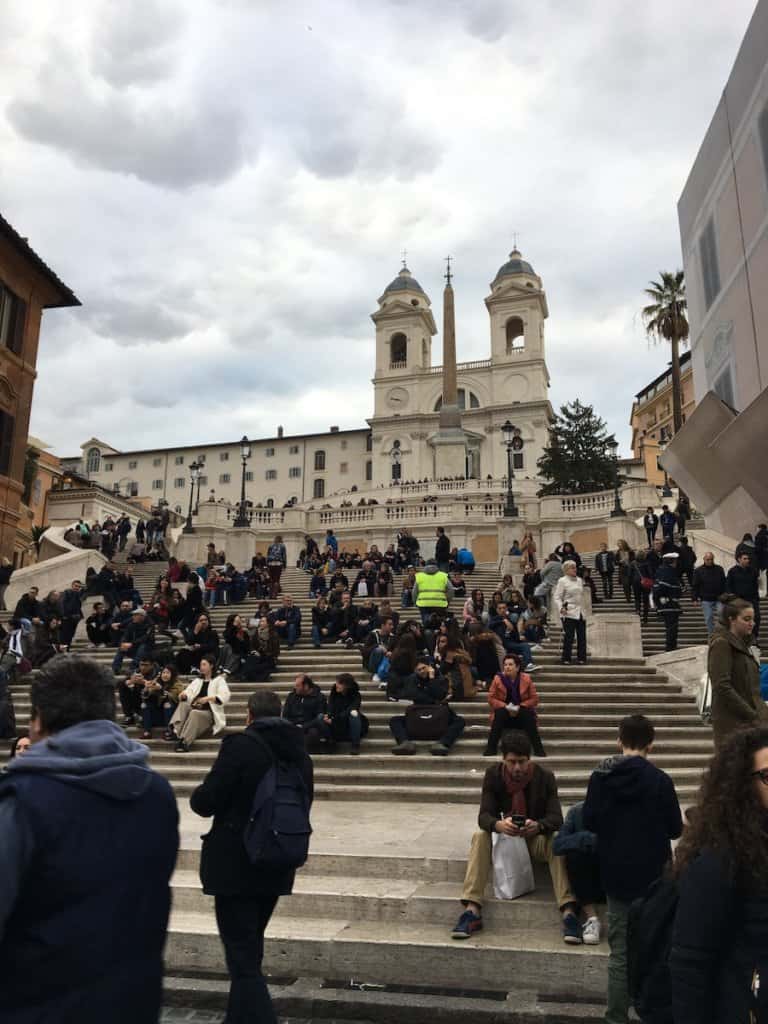 View from the bottom of the Spanish steps with people sitting on them 