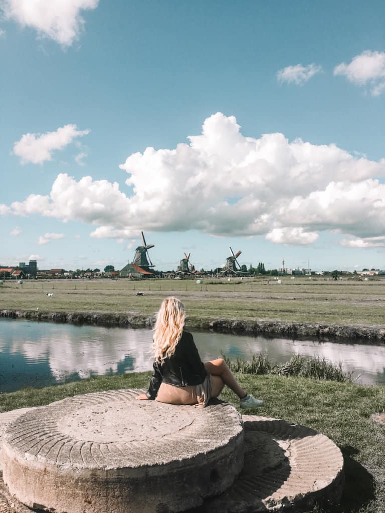 Girl sitting with dutch windmills in the distance