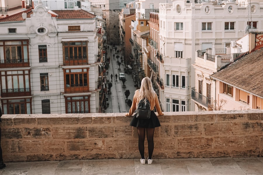 Girl standing at the ledge of Torres De Serrans overlooking the city 