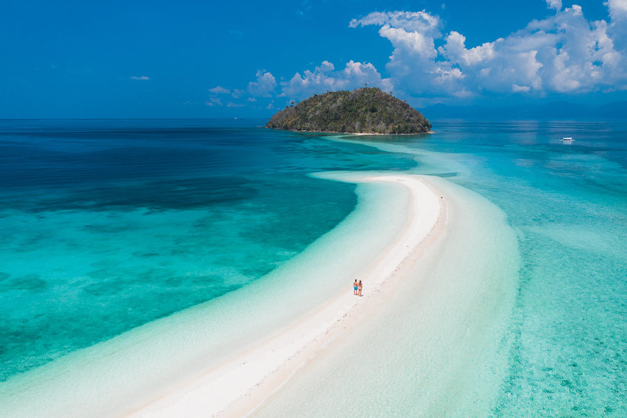 White sand beach in the middle of the vivid blue ocean