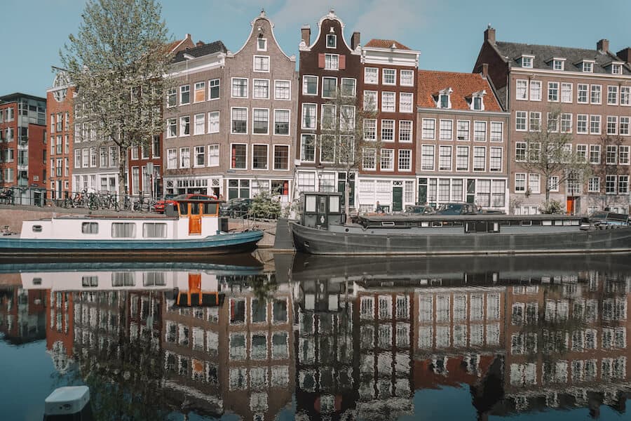 Canal in Amsterdam with houses reflecting off the water 
