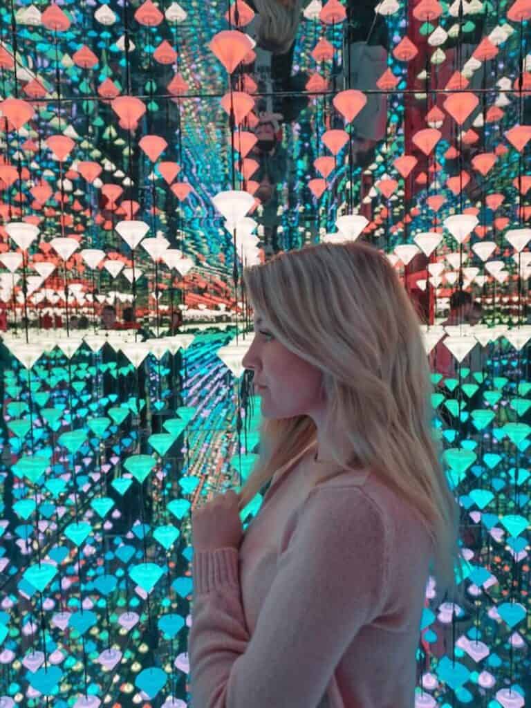 girl standing in front of lights display 