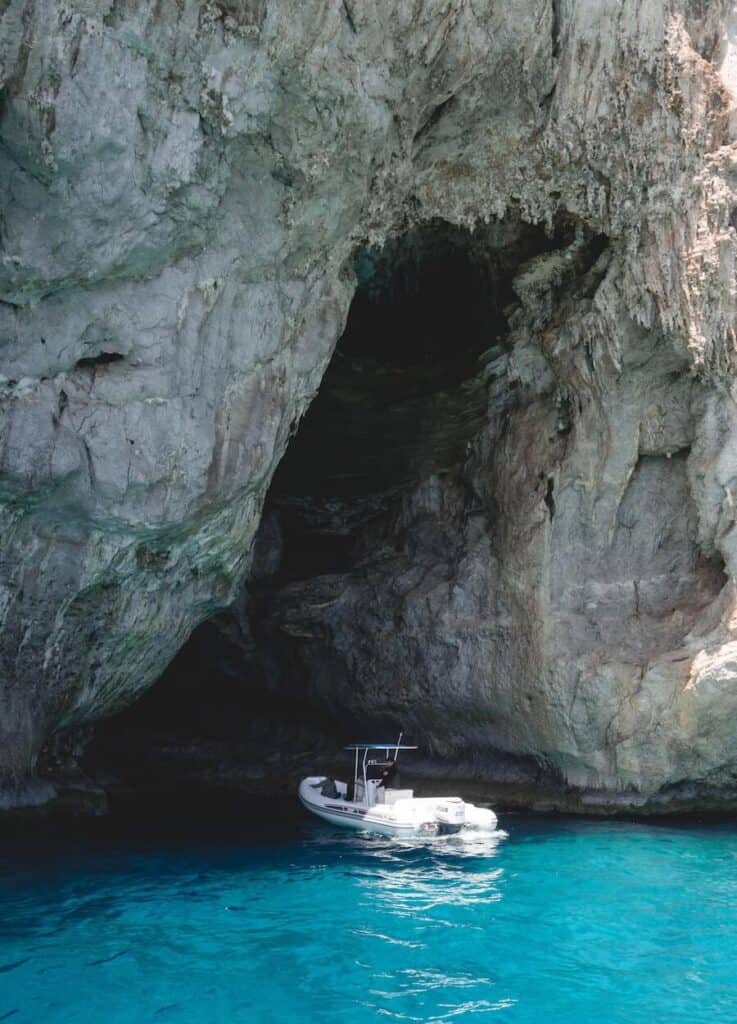 Boat in the water under a cliff