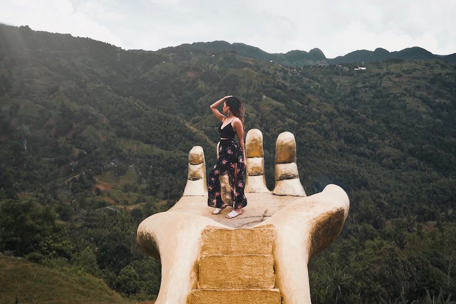 beautiful places in Cebu - girl standing on a hand overlooking the hilly landscape