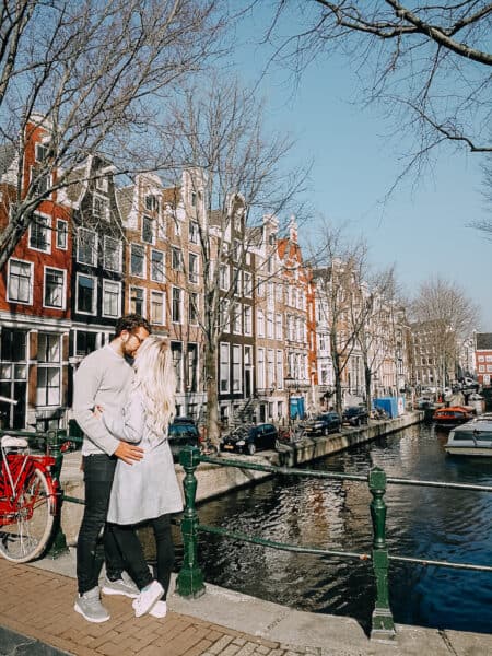 Two people standing on a canal in Amsterdam