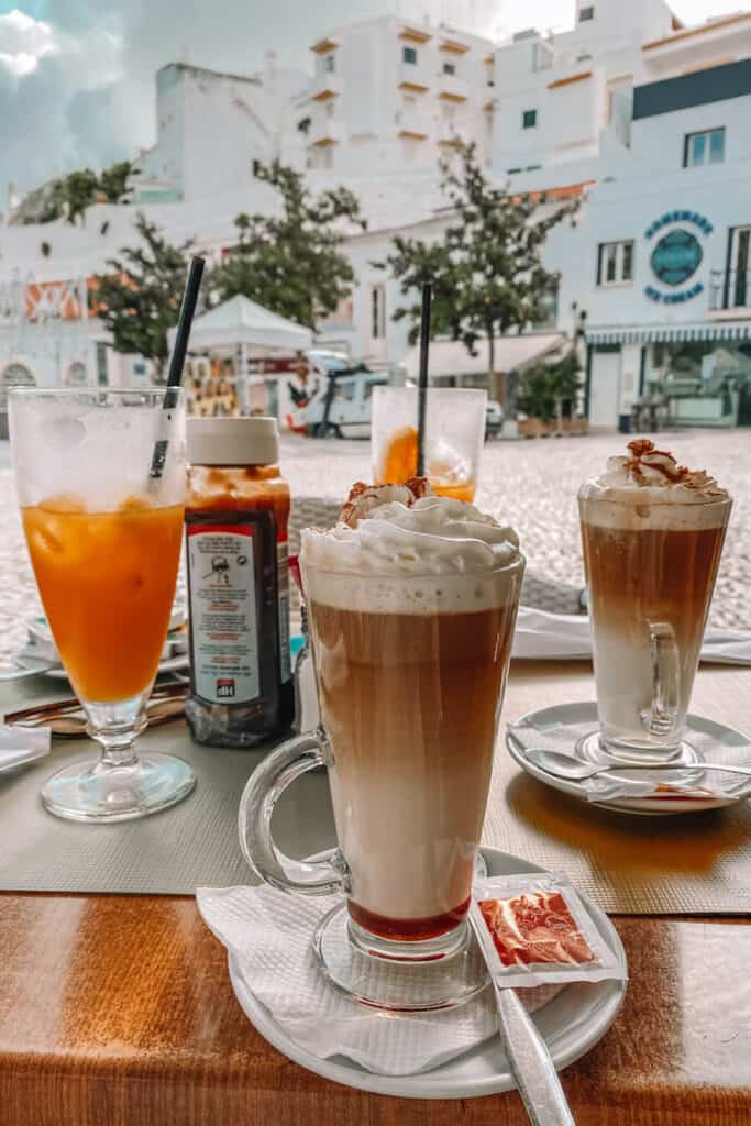 Specialty coffees at a cafe with white buildings in the distance