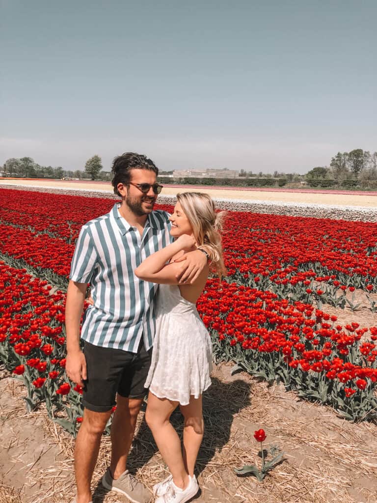 Two people in front of red tulips in the Netherlands