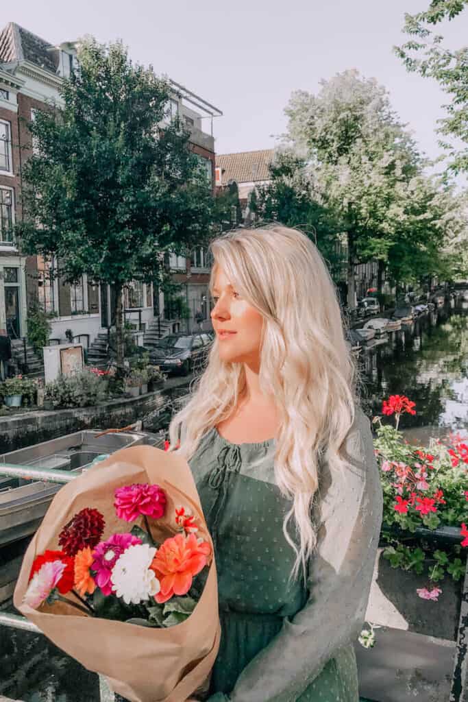 girl standing on a canal with flowers
