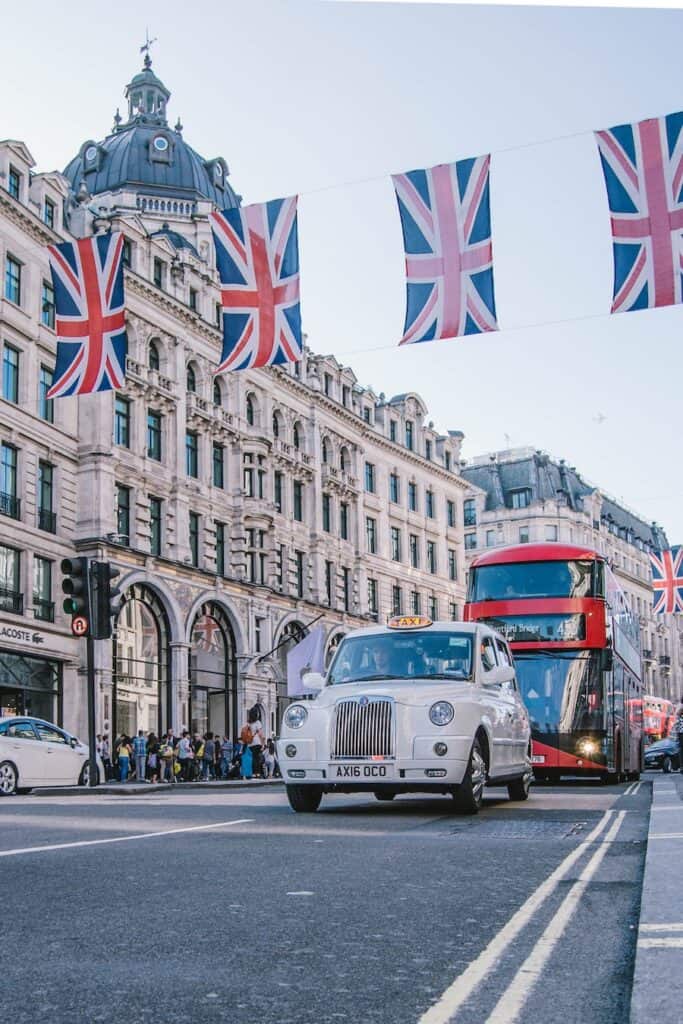 Street with UK flags and a white UK taxi