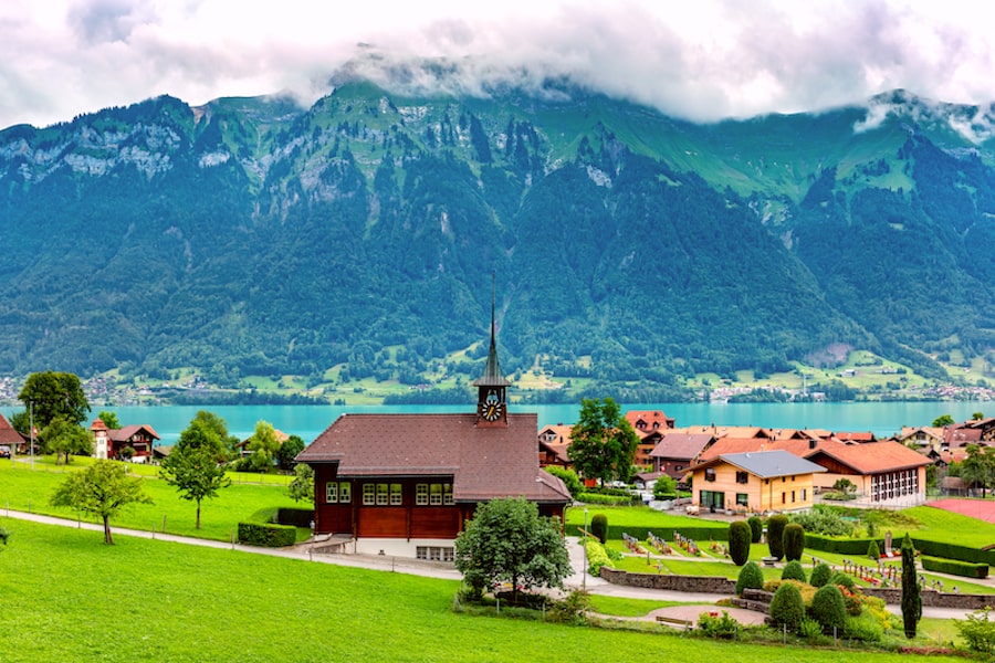 Panoramic view of swiss village Iseltwald with traditional wood church on the southern shore of Lake Brienz, Switzerland