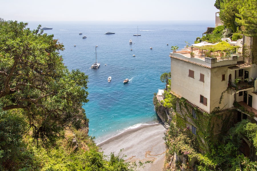 Top view to the little beach Spiaggia la Porta with the luxury yachts in Positano city, Amalfi coast, Italy