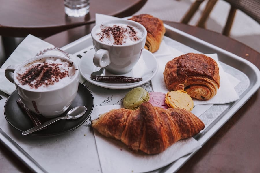 Two cappuccinos and pastries on a table in Paris