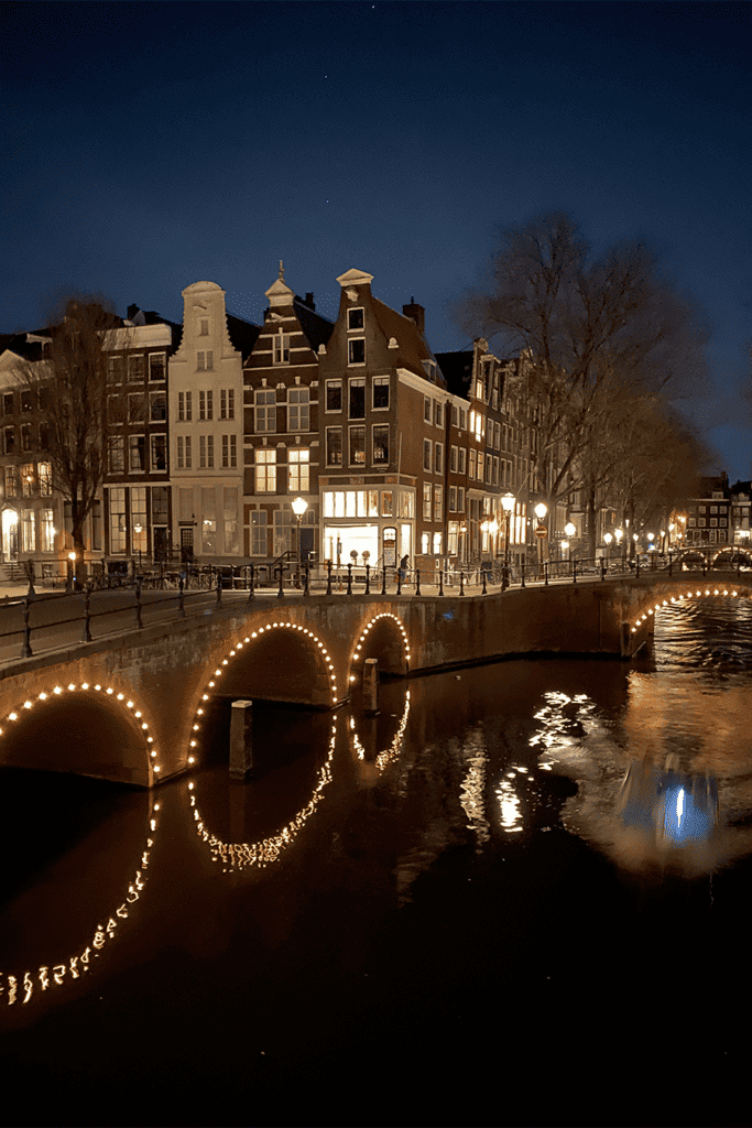 Enlightened bridge and canals of Amsterdam during nighttime. 
