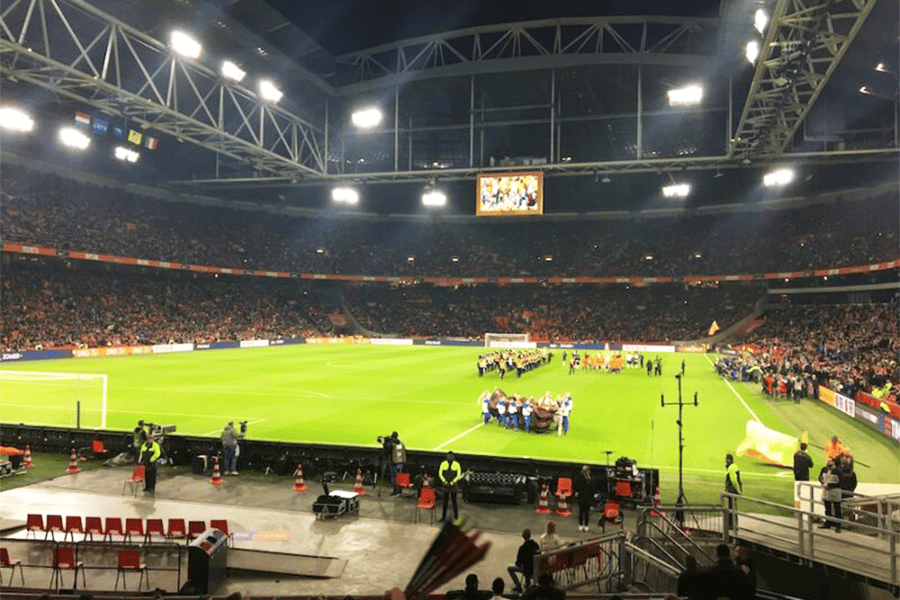 Players walking onto the pitch of the Johan Cruijff Arena in Amsterdam. 