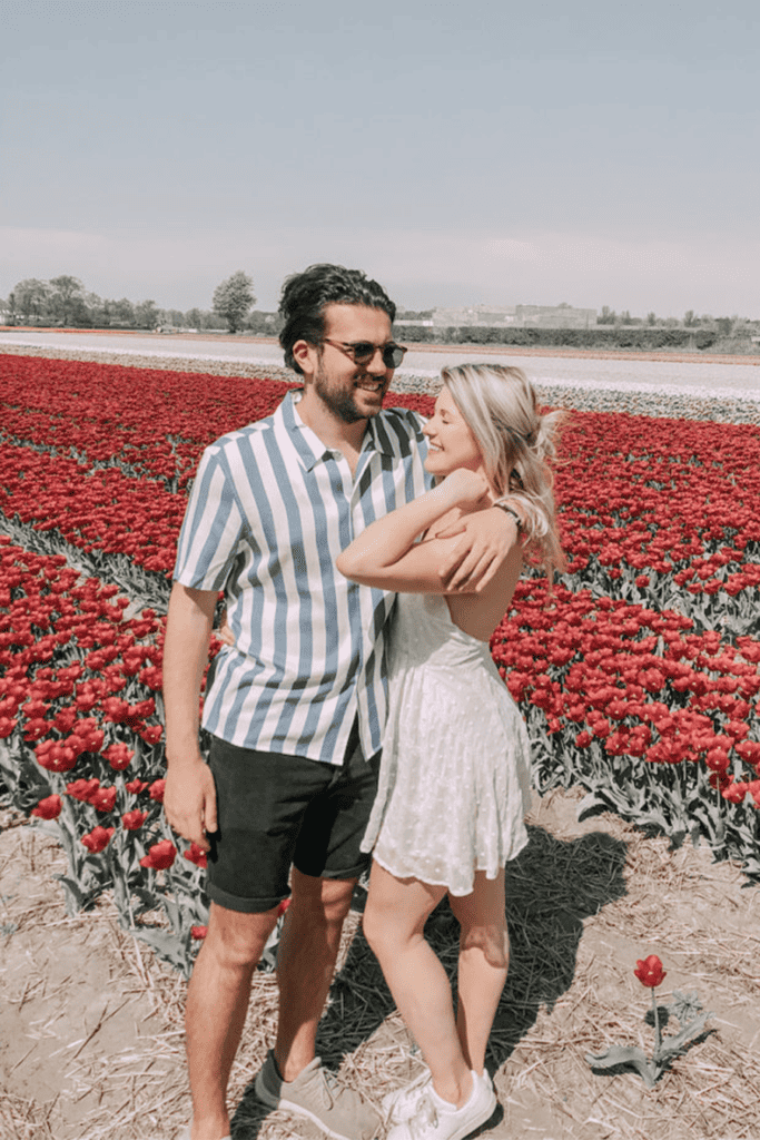 Couple hugging in tulip fields.