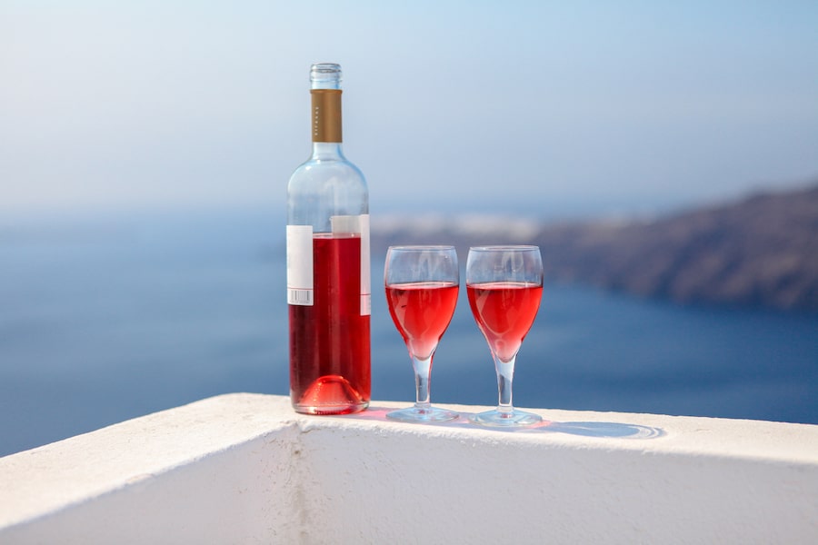 Two glasses and bottle of tasty red wine at sunset in Greece