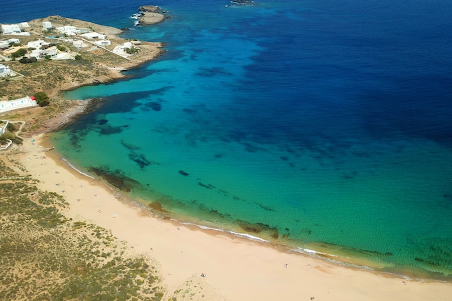 Aerial drone bird's eye view photo of iconic turquoise clear water sandy beach of Agios Sostis in island of Mykonos, Cyclades, Greece