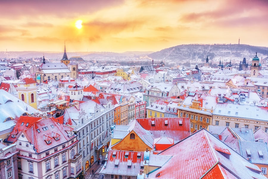 Prague down town center at winter Christmas time, classical view on snowy roofs in central part of city.