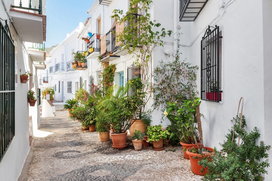 Picturesque narrow street decorated with plants. Frigiliana, Andalusia, Spain.