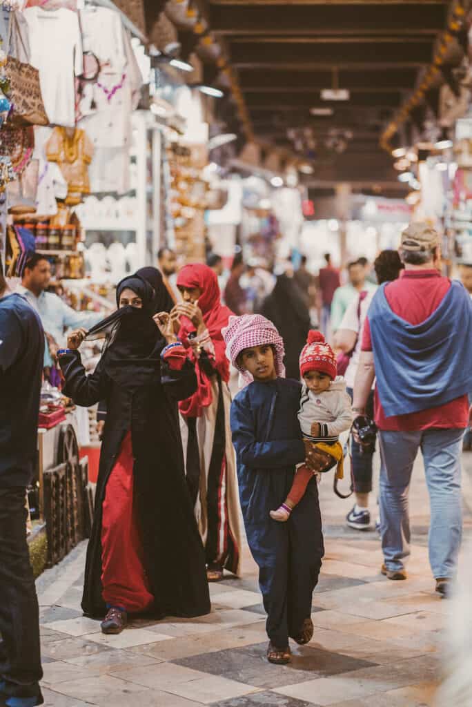 Group of Muslim people shopping in Mutrah Souq covered market