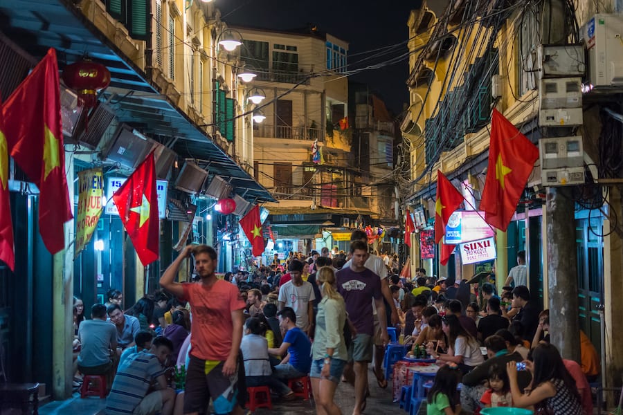 Tourists enjoying beer on busy Hanoi street full of bars