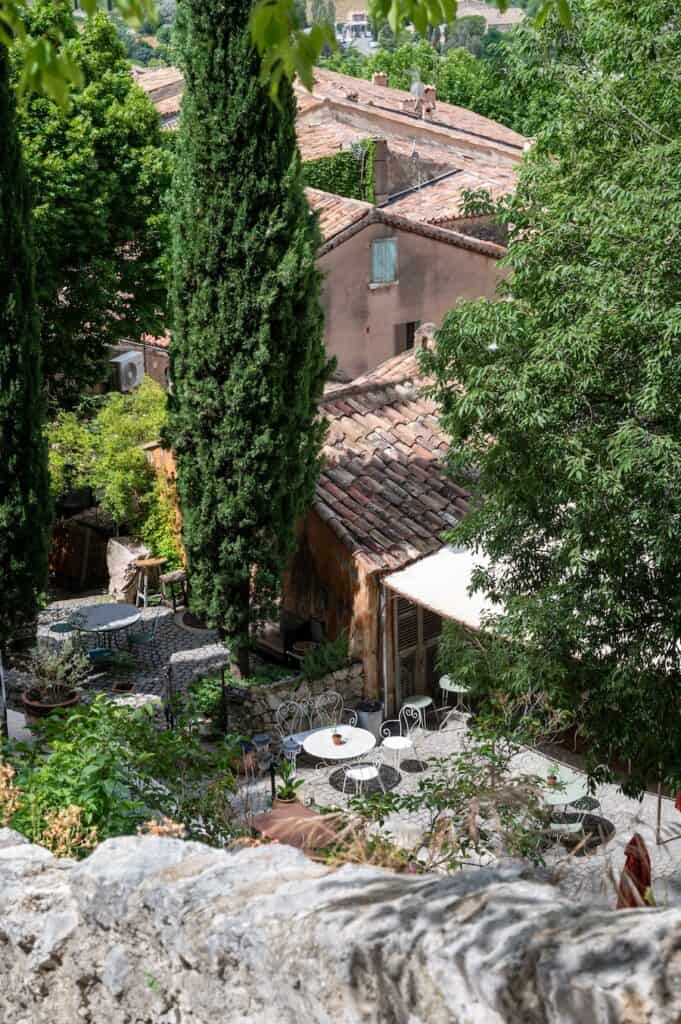 View on mountains cliff, old houses, green valley in remote medieval village Moustiers-Sainte-Marie in Provence, France. Touristic destination.