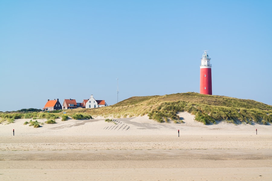 Beach, dunes and lighthouse of De Cocksdorp on West Frisian Waddensea island Texel, Netherlands