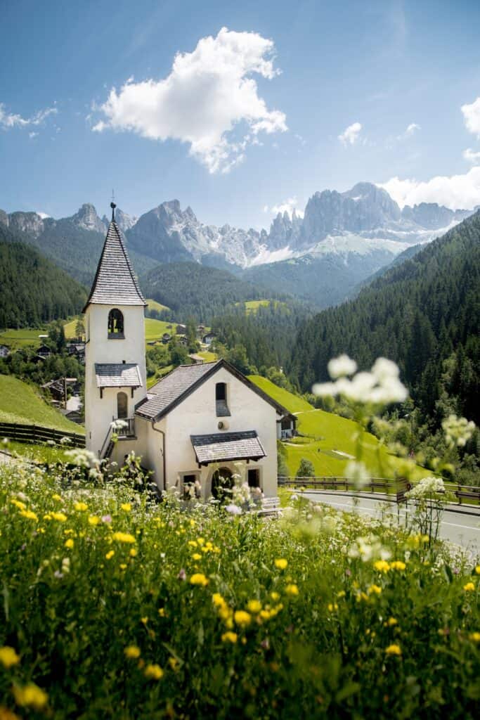 Beautiful panoramic view of scenic Dolomites mountain scenery with the church of Tiers am Rosengarten, South Tyrol region, northern Italy