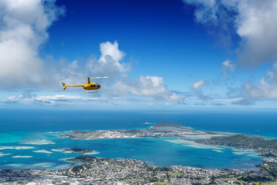 Aerial view of helicopter from high a ridge trail overlooking Kaneohe on Oahu, Hawaii